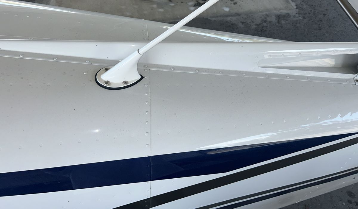 Polished upper wing surface and antenna base on a high-wing Cessna after detailing